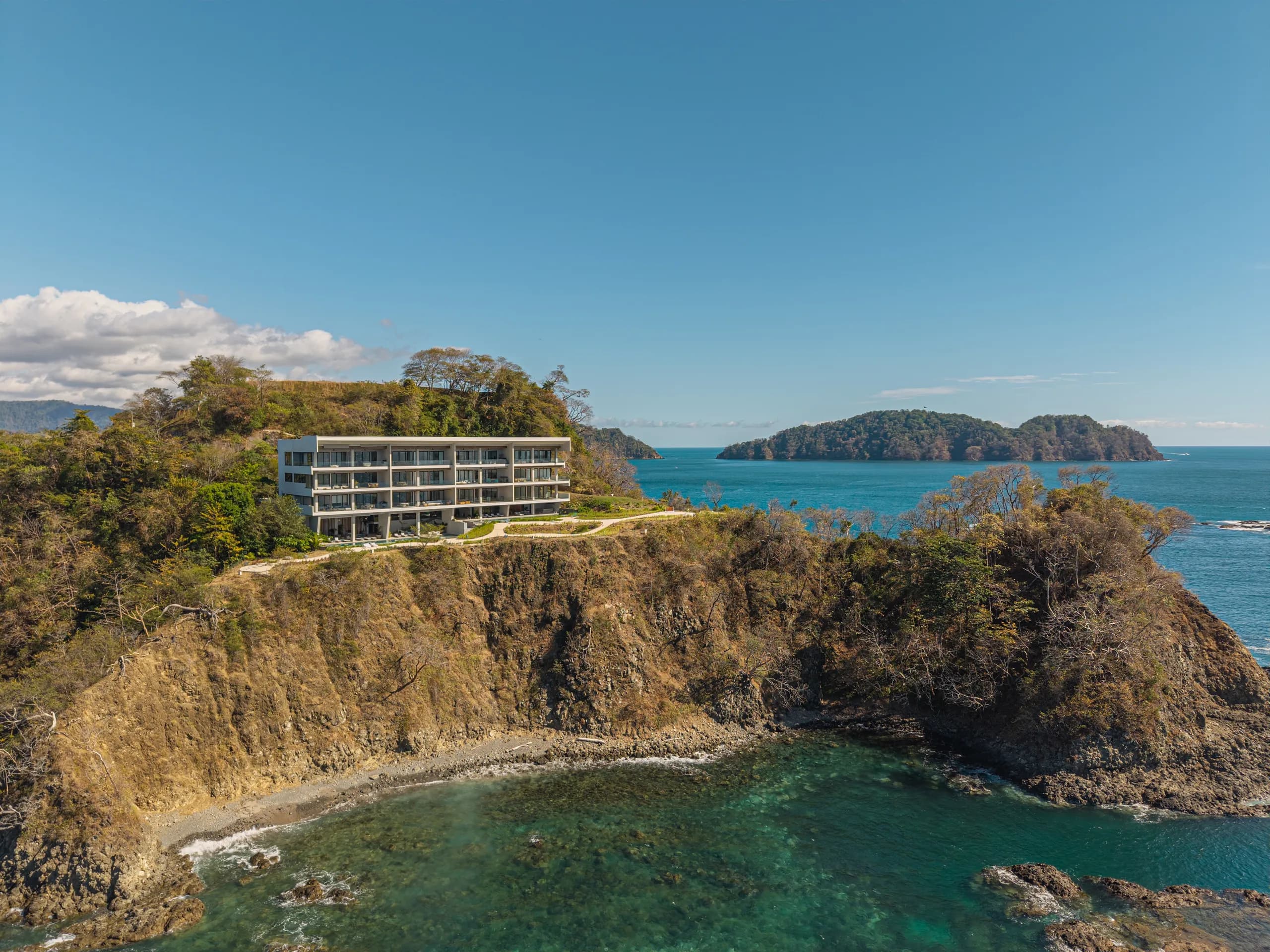 Aerial view of Nerea perched on a cliff peninsula over the Pacific